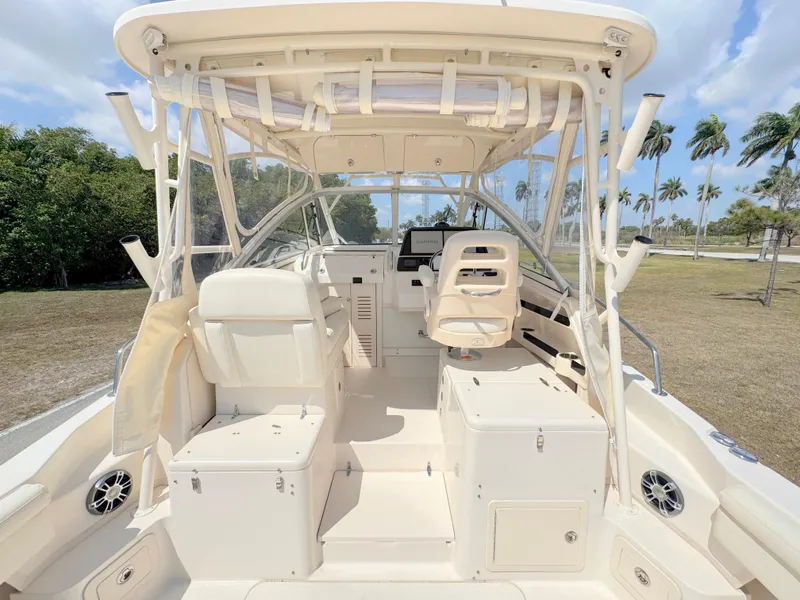 Slide: The Image of 2022 Grady-White Marlin 300 boat interior with seating and helm, set against a tropical backdrop. - 46