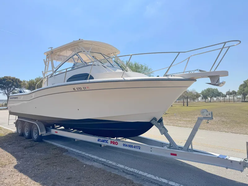 Slide: The Image of 2022 Grady-White Marlin 300 boat on trailer, parked outdoors under clear sky. - 6