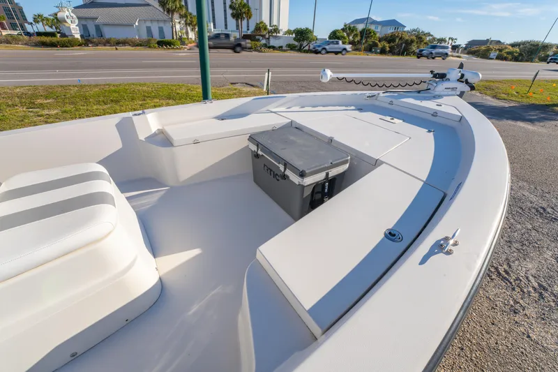 Slide: The Image of 2001 Pathfinder 2400-V boat with seating and storage, parked near a road. - 12