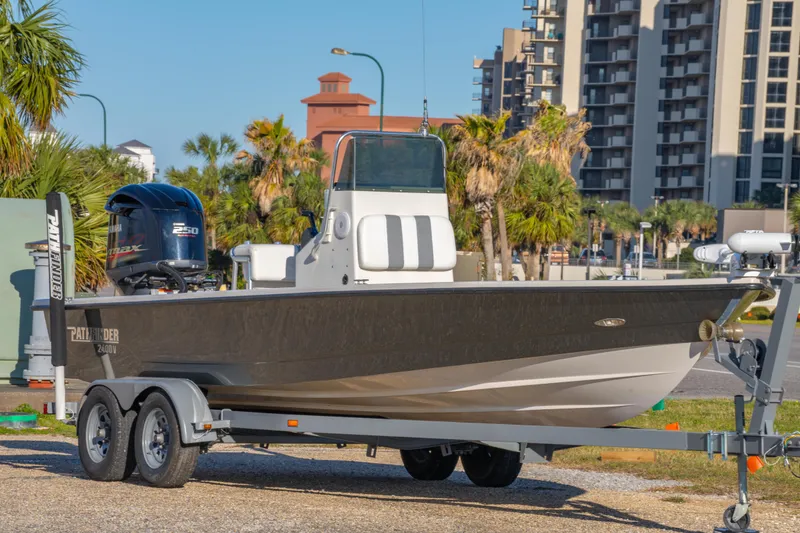 Slide: The Image of 2001 Pathfinder 2400-V boat on trailer, parked near palm trees and buildings. - 3