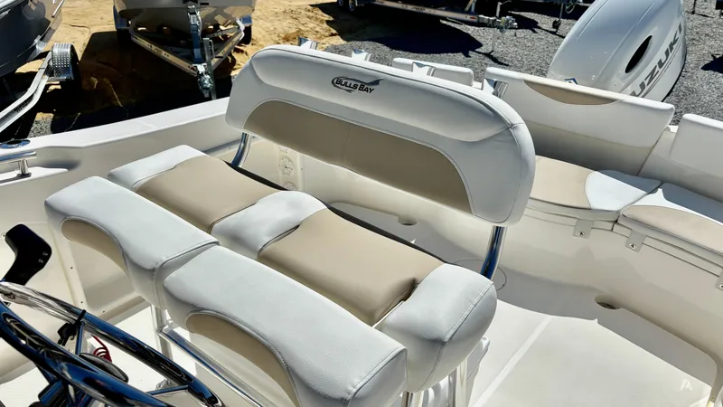 Slide: The Image of 2025 Bulls Bay 230CC boat interior with cushioned seating and steering console. - 10