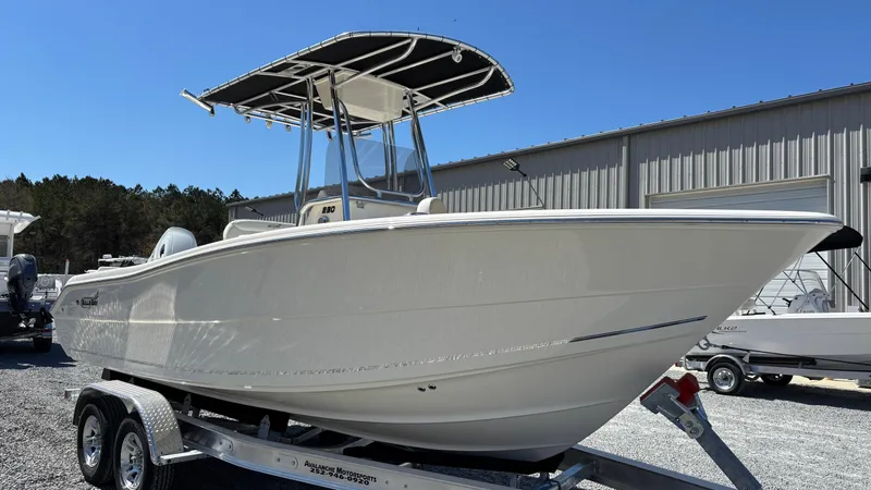 Slide: The Image of 2025 Bulls Bay 230CC boat on trailer, white hull, T-top, outdoor display. - 3