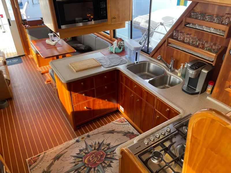 Slide: The Image of Luxurious 2002 Canoe Cove 50 Pilothouse Yacht kitchen with wood cabinetry and modern appliances. - 11