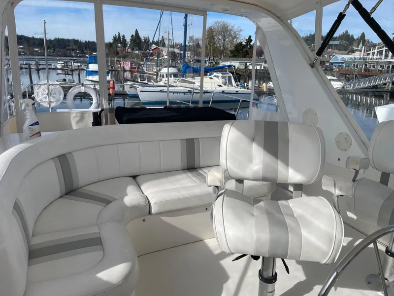 Slide: The Image of Luxurious 2002 Canoe Cove 50 Pilothouse Yacht interior with plush seating and marina view. - 13