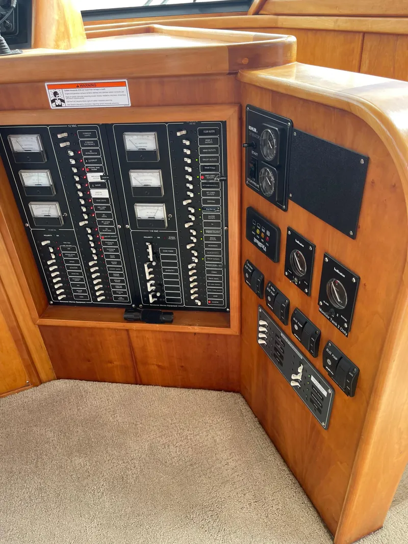 Slide: The Image of Control panel of a 2002 Canoe Cove 50 Pilothouse Luxury Yacht, featuring various switches and gauges. - 14