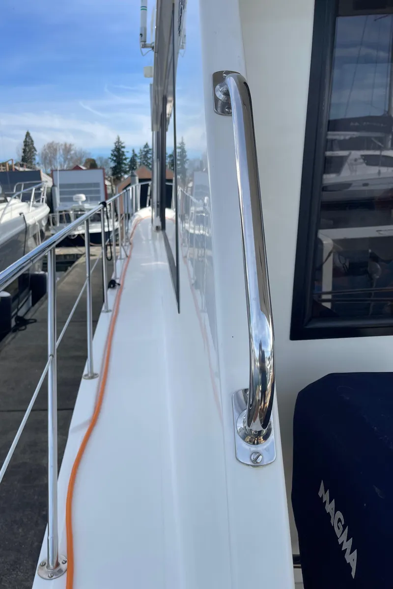 Slide: The Image of 2002 Canoe Cove 50 Pilothouse Yacht, side deck view with railing and window. - 23