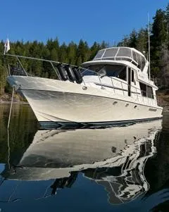 Slide: The Image of 2002 Canoe Cove 50 Pilothouse Luxury Yacht on tranquil water, surrounded by trees. - 26