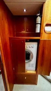 Slide: The Image of Laundry area with washer in 2002 Canoe Cove 50 Pilothouse Luxury Yacht. - 28