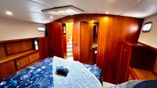 Slide: The Image of Luxurious bedroom interior of 2002 Canoe Cove 50 Pilothouse Yacht with wooden cabinetry. - 3