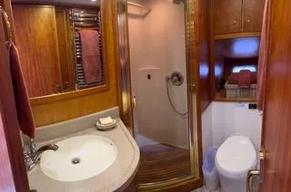 Slide: The Image of Luxurious bathroom in 2002 Canoe Cove 50 Pilothouse Yacht with wood accents and modern fixtures. - 34