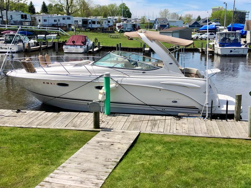 Slide: The Image of 2005 Chaparral Signature 310 boat docked in a marina with lush greenery. - 2