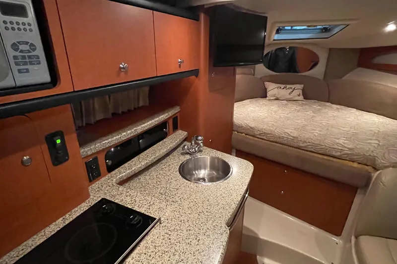 Slide: The Image of 2005 Chaparral Signature 310 cabin interior with kitchenette and cozy sleeping area. - 8