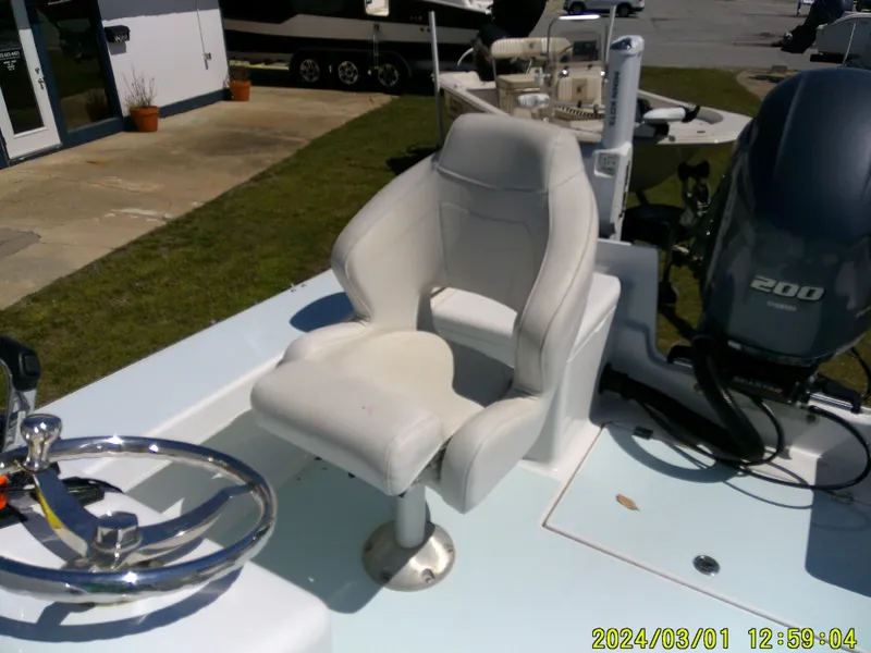 Slide: The Image of White captain's chair on 2020 Southern Cross 23 boat, with steering wheel and motor visible. - 35