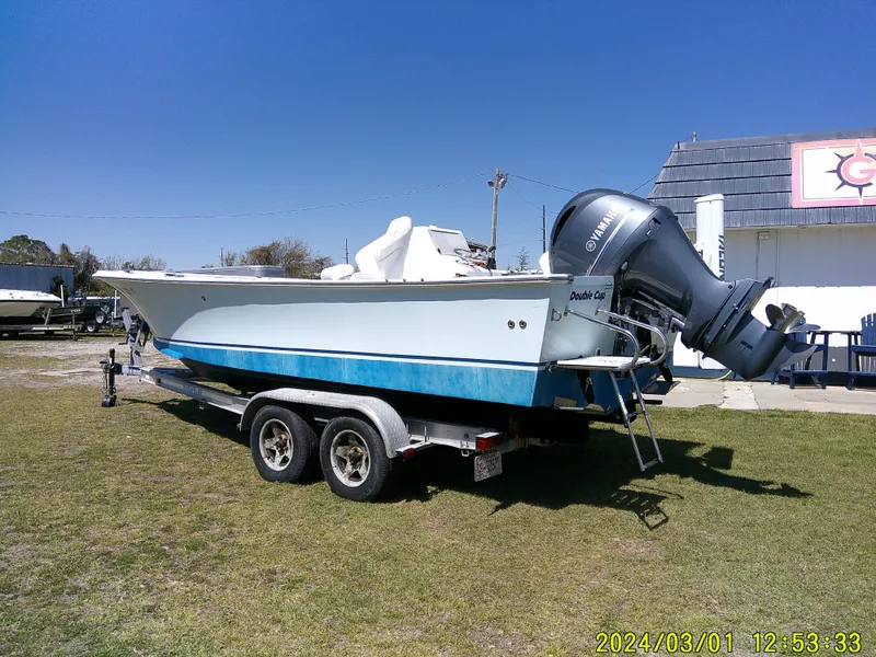 Slide: The Image of Southern Cross 23 boat on trailer, 2020 model, parked on grass under clear blue sky. - 5