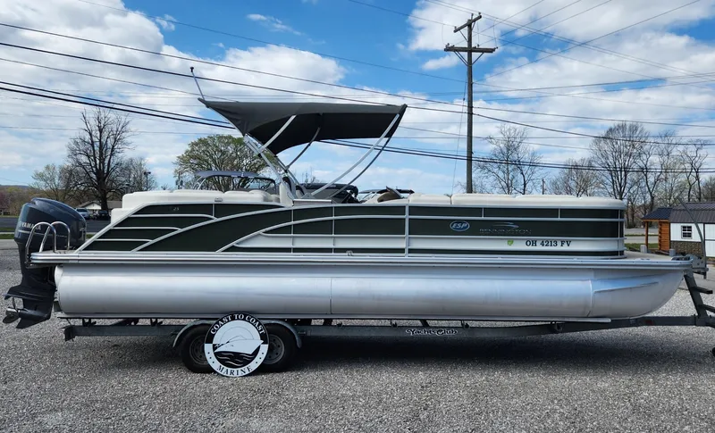Slide: The Image of 2017 Bennington R5 2550 RCFS Saltwater Edition pontoon boat on trailer, parked outdoors. - 1