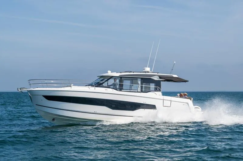 Slide: The Image of 2025 Jeanneau NC 1295 Coupe cruising on open water, side view. - 10