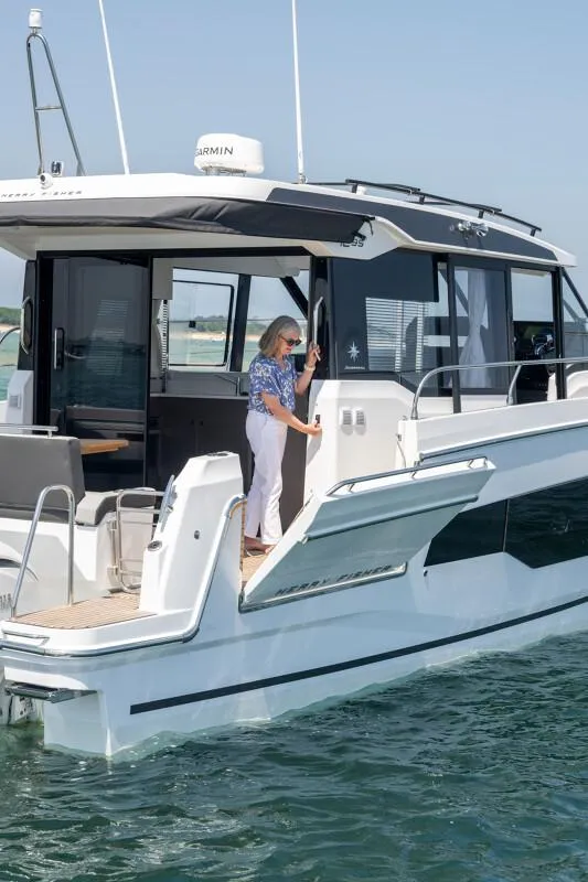 Slide: The Image of 2025 Jeanneau NC 1295 Coupe yacht on water, featuring sleek design and modern amenities. - 14