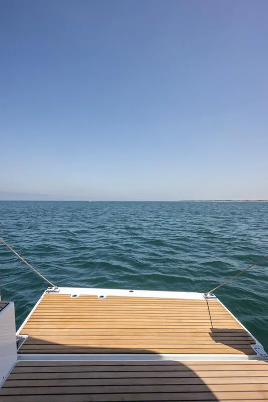 Slide: The Image of 2025 Jeanneau NC 1295 Coupe boat deck overlooking calm ocean waters. - 21