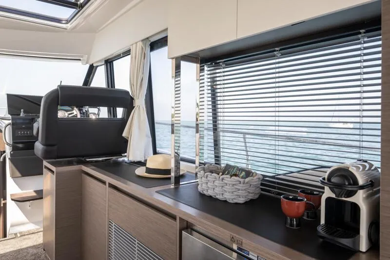 Slide: The Image of Interior of 2025 Jeanneau NC 1295 Coupe yacht with modern kitchen amenities and ocean view. - 40