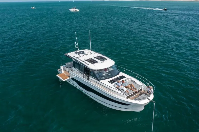 Slide: The Image of 2025 Jeanneau NC 1295 Coupe cruising on open water, featuring sleek design and spacious deck. - 5