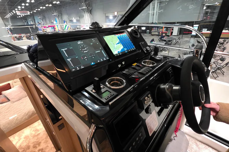 Slide: The Image of 2026 Jeanneau NC 1295 Coupe helm with advanced navigation displays and controls. - 81