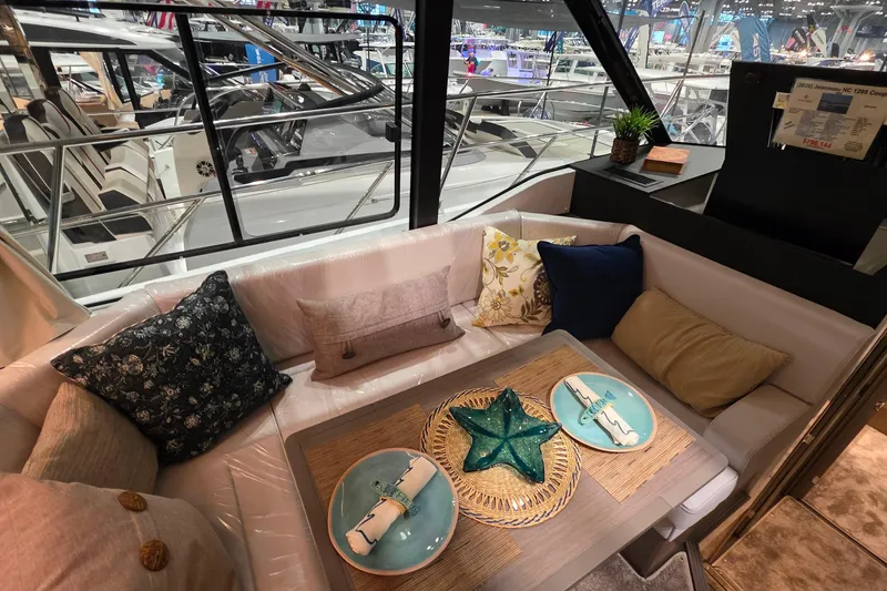 Slide: The Image of Interior of 2026 Jeanneau NC 1295 Coupe with elegant dining setup and plush seating. - 82