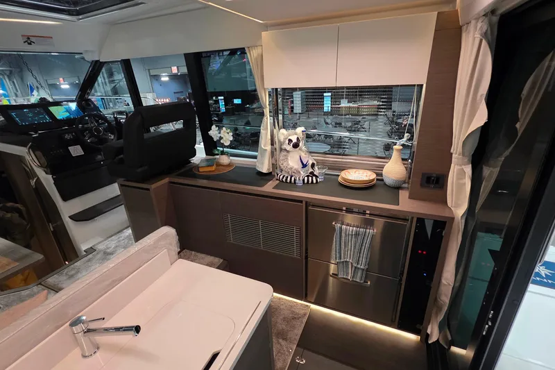 Slide: The Image of Interior of 2026 Jeanneau NC 1295 Coupe, featuring modern kitchen and helm station. - 84