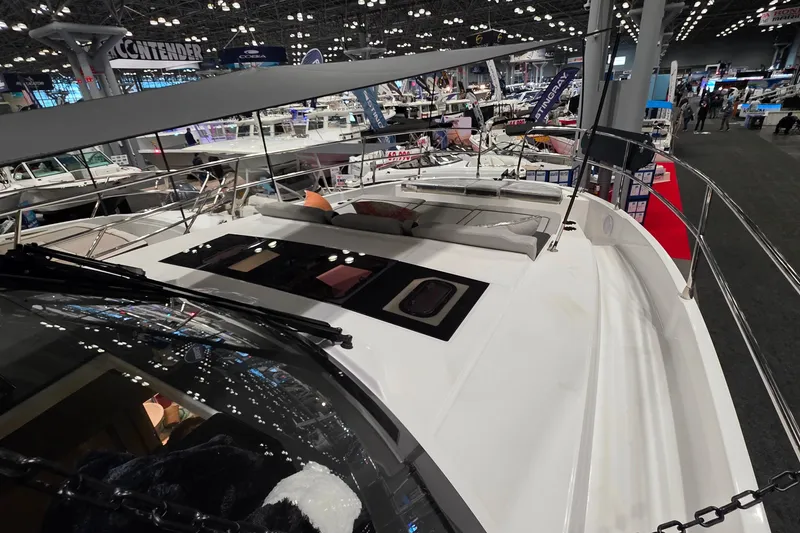Slide: The Image of 2026 Jeanneau NC 1295 Coupe showcased at a boat exhibition, featuring sleek design and spacious deck. - 88