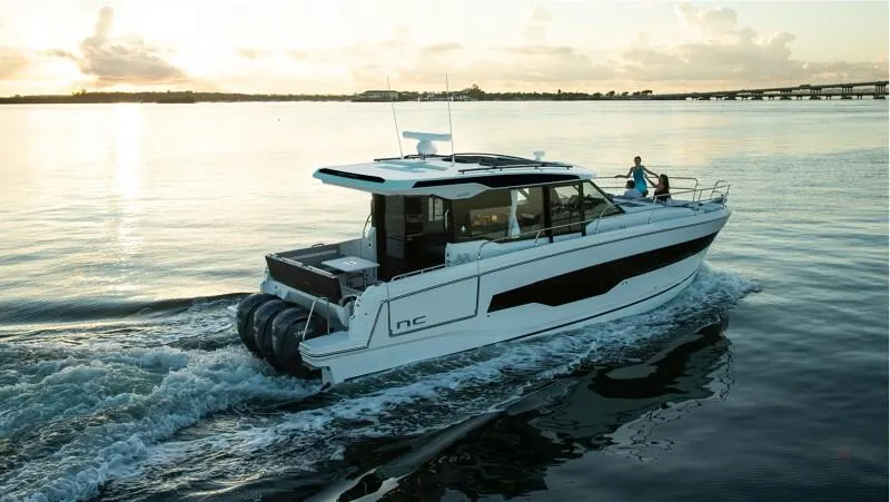 Slide: The Image of 2025 Jeanneau NC 1295 Coupe cruising on calm waters at sunset. - 9