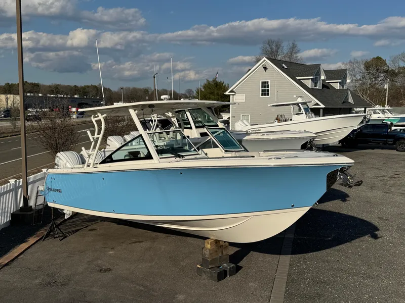 Slide: The Image of 2024 Sailfish 276 DC boat in blue, displayed outdoors on a sunny day. - 0