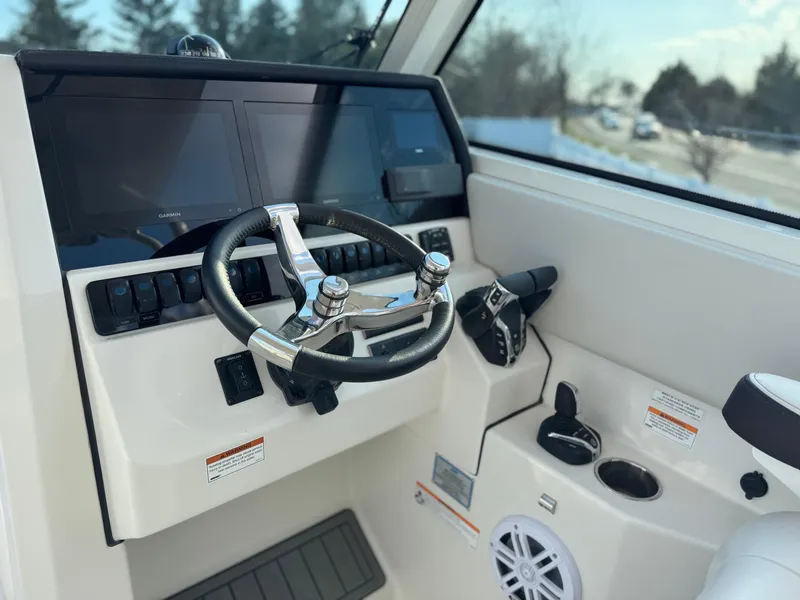 Slide: The Image of 2024 Sailfish 276 DC boat helm with steering wheel and control panel. - 11