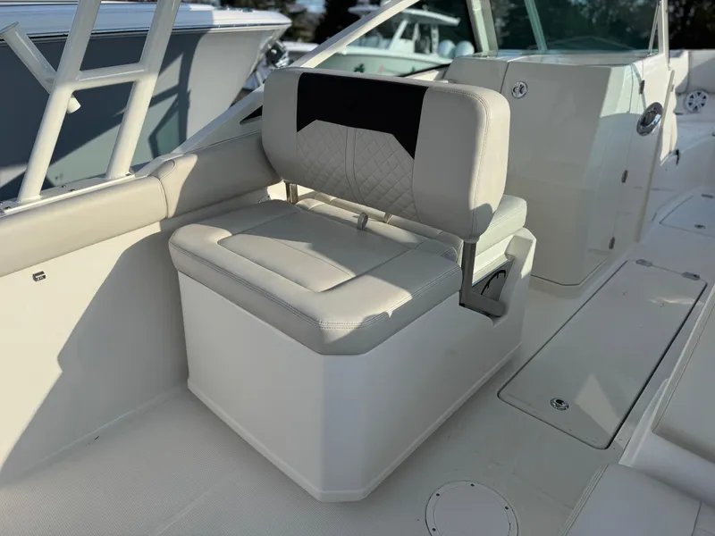 Slide: The Image of 2024 Sailfish 276 DC boat interior seating with cushioned bench and storage. - 13