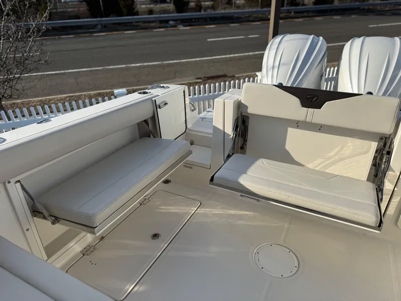 Slide: The Image of 2024 Sailfish 276 DC boat interior with foldable seating and white upholstery. - 16