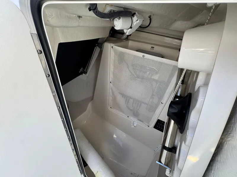 Slide: The Image of 2024 Sailfish 276 DC interior storage compartment with netting and equipment. - 18