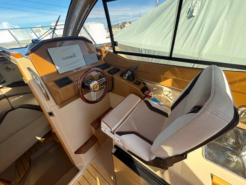Slide: The Image of 2017 Cutwater C-242 Sport Coupe helm with Garmin navigation, featuring a comfortable captain's chair. - 12
