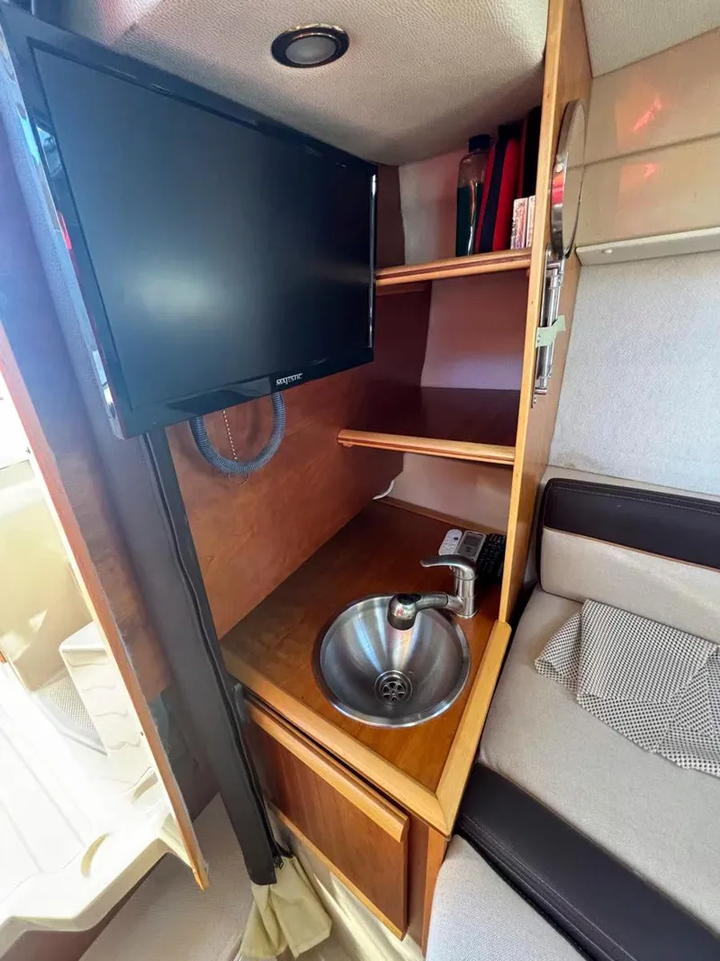 Slide: The Image of 2017 Cutwater C-242 Sport Coupe interior with TV, sink, and shelving. - 15