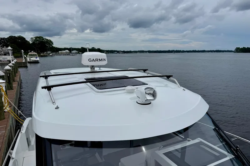 Slide: The Image of 2026 Beneteau Antares 9 boat with Garmin equipment on a calm lake. - 11