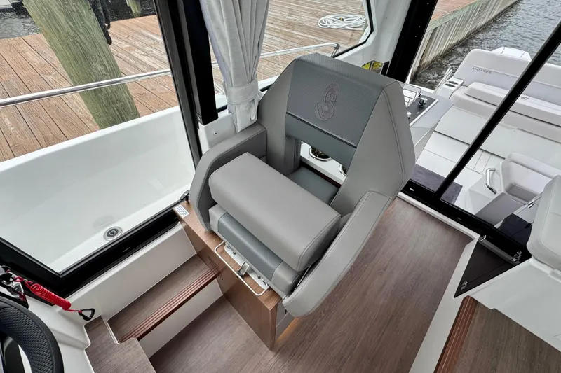 Slide: The Image of 2026 Beneteau Antares 9 interior helm seat with modern design and wood flooring. - 18