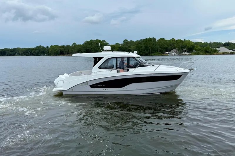 Slide: The Image of 2026 Beneteau Antares 9 cruising on a calm lake with lush green shoreline. - 2