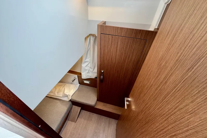 Slide: The Image of 2026 Beneteau Antares 9 cabin interior with wooden finish and cozy bedding. - 23
