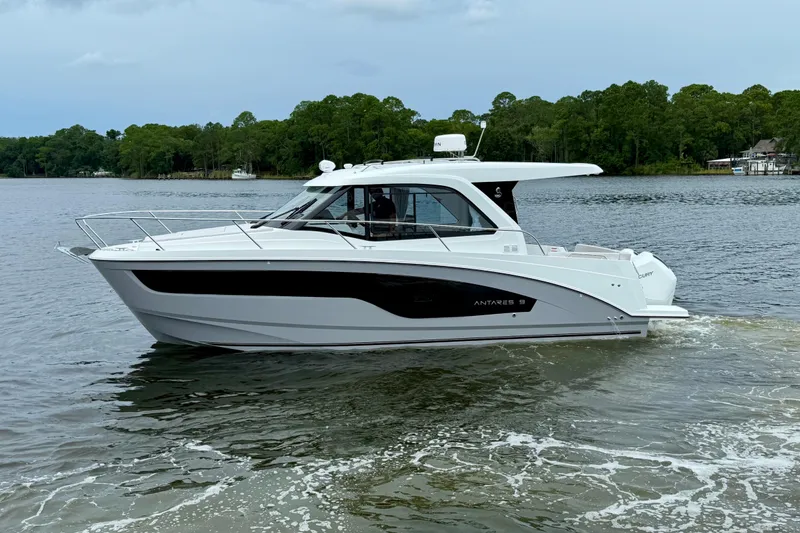 Slide: The Image of 2026 Beneteau Antares 9 cruising on a serene lake with lush green forest backdrop. - 4