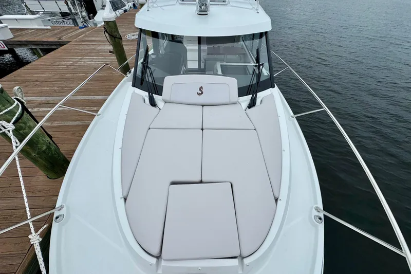 Slide: The Image of 2026 Beneteau Antares 9 boat with cushioned deck, docked by wooden pier. - 8
