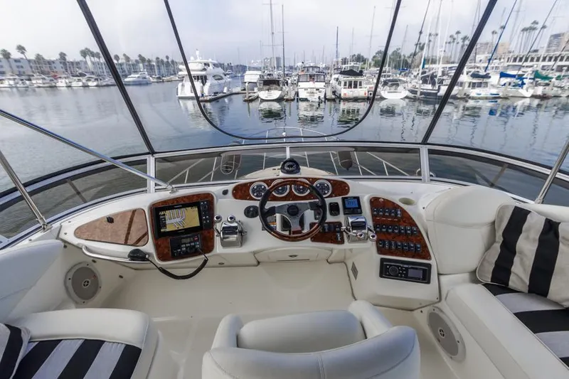 Slide: The Image of 2005 Meridian 459 Motoryacht helm with marina view, featuring modern navigation equipment and luxurious seating. - 22