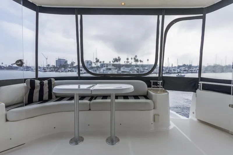 Slide: The Image of 2005 Meridian 459 Motoryacht interior with seating and table, overlooking marina. - 29