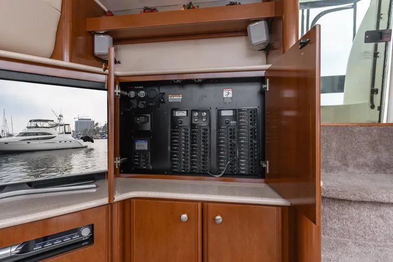 Slide: The Image of Electrical panel inside 2005 Meridian 459 Motoryacht, with open cabinet and marina view. - 46