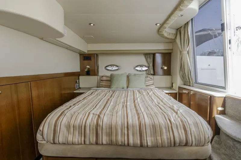 Slide: The Image of Luxurious bedroom interior of 2005 Meridian 459 Motoryacht with striped bedding and large window. - 48