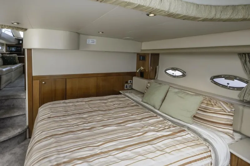 Slide: The Image of Luxurious bedroom interior of 2005 Meridian 459 Motoryacht with striped bedding and porthole windows. - 49