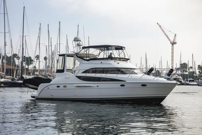 Slide: The Image of 2005 Meridian 459 Motoryacht docked in a marina with sailboats and cranes. - 6