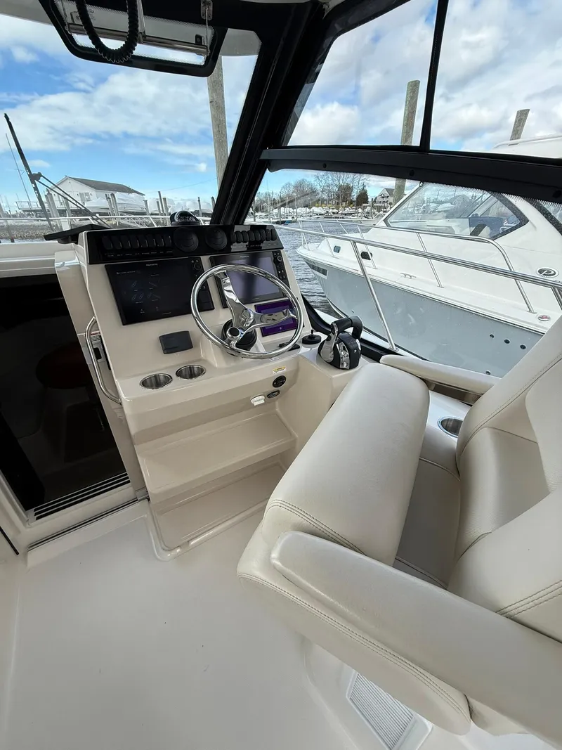 Slide: The Image of 2020 Boston Whaler 325 Conquest helm with modern controls and comfortable seating. - 14