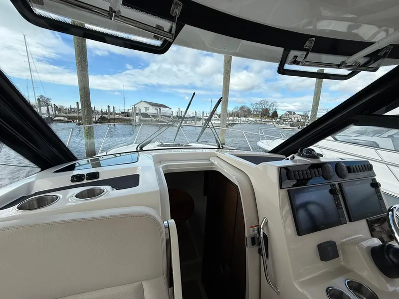 Slide: The Image of 2020 Boston Whaler 325 Conquest cockpit with marina view, featuring modern controls and seating. - 17